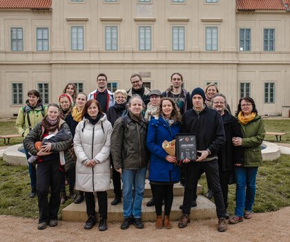 Tým, který se podílel na výzkumu a vyhodnocení nálezů z jímky a na vzniku publikace. Knihu drží hlavní spoluautoři knihy archeoložka Marcela Waldmannová a historik Jakub Krček. Foto T. Chlup, 2024.